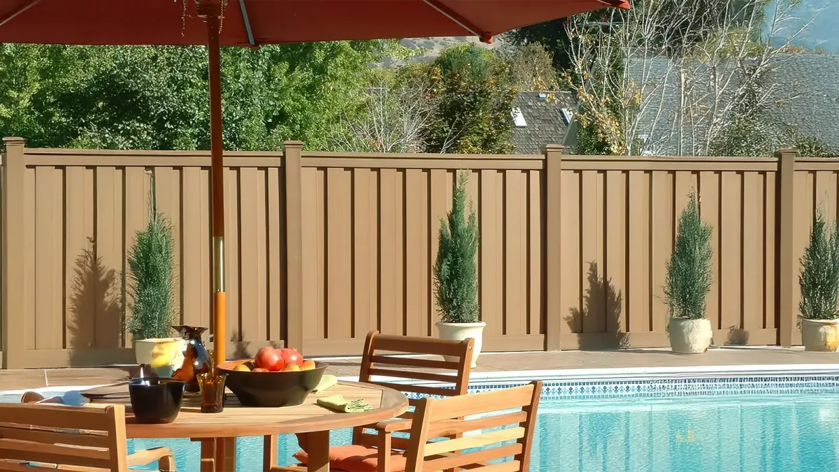 Trex Seclusions vertical composite privacy fence beside a pool and patio