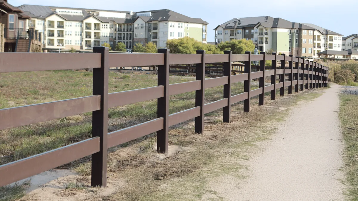 Trex Shenandoah open three-rail composite fence alongside a path